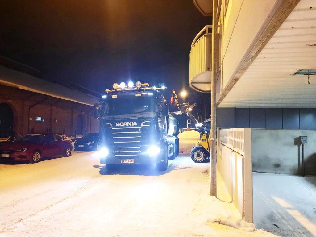 en foto av en lastbil och en skoptraktorn bakom väggen